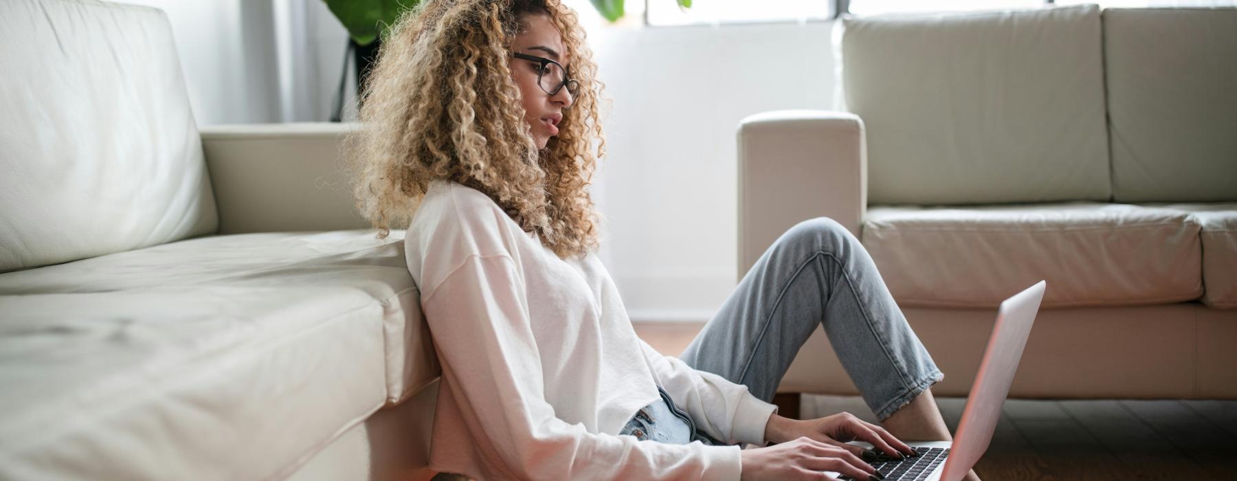 a person sitting on a couch with a laptop
