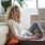 a person sitting on a couch with a laptop